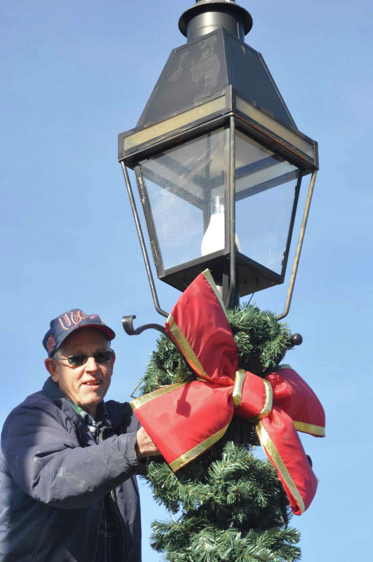 Veteran John Knoche decorated lampposts for the season Saturday, Nov. 23, as a crew of about 25 , half from the American Legion and half from its youth baseball team, decorated 57 village lampposts.