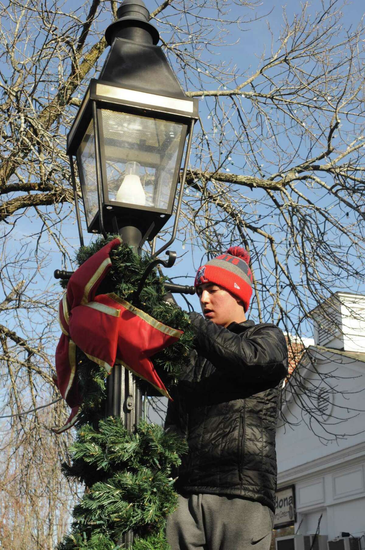 Will Hanna was one of the players from the American Legion baseball team out decorating village lampposts Saturday, Nov. 23, in a joint effort with veterans from American Legion Post 78.