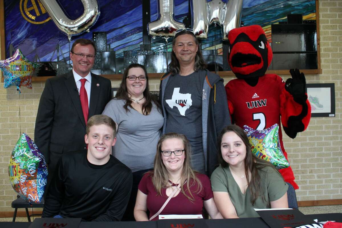 Pictured from front left to right in the back row are Thomas Evans, president of the University of the Incarnate Word, Karryn Peters, the mother of triplets, Paul Harris, Alamo Heights High School counselor, and the UIW mascot Red. Pictured from left to right in the front row are Matthew, Melanie and Madelyn Peters. UIW surprised the three students with college scholarships to the university on Thursday, Nov. 21.