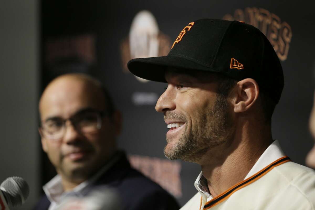 San Francisco Giants manager Gabe Kapler, right, smiles during a news conference as president of baseball operations Farhan Zaidi looks on at Oracle Park Wednesday, Nov. 13, 2019, in San Francisco. Gabe Kapler has been hired as manager of the San Francisco Giants, a month after being fired from the same job by the Philadelphia Phillies. Kapler replaces Bruce Bochy, who retired at the end of the season following 13 years and three championships with San Francisco. (AP Photo/Eric Risberg)