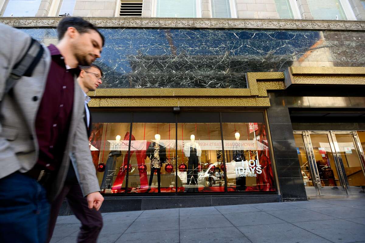 Pedestrians pass a display window at Macy's Union Square store on Monday, Nov. 25, 2019, in San Francisco.