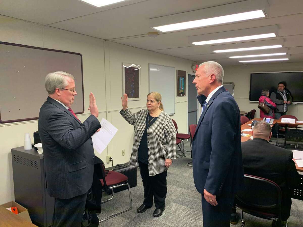 Joseph McQuade, one of the Ansonia Board of Education’s lawyers, swears in Phil Tripp, as the new member and Fran DiGiorgi who was re-elected during the special meeting on Nov. 22, 2019.