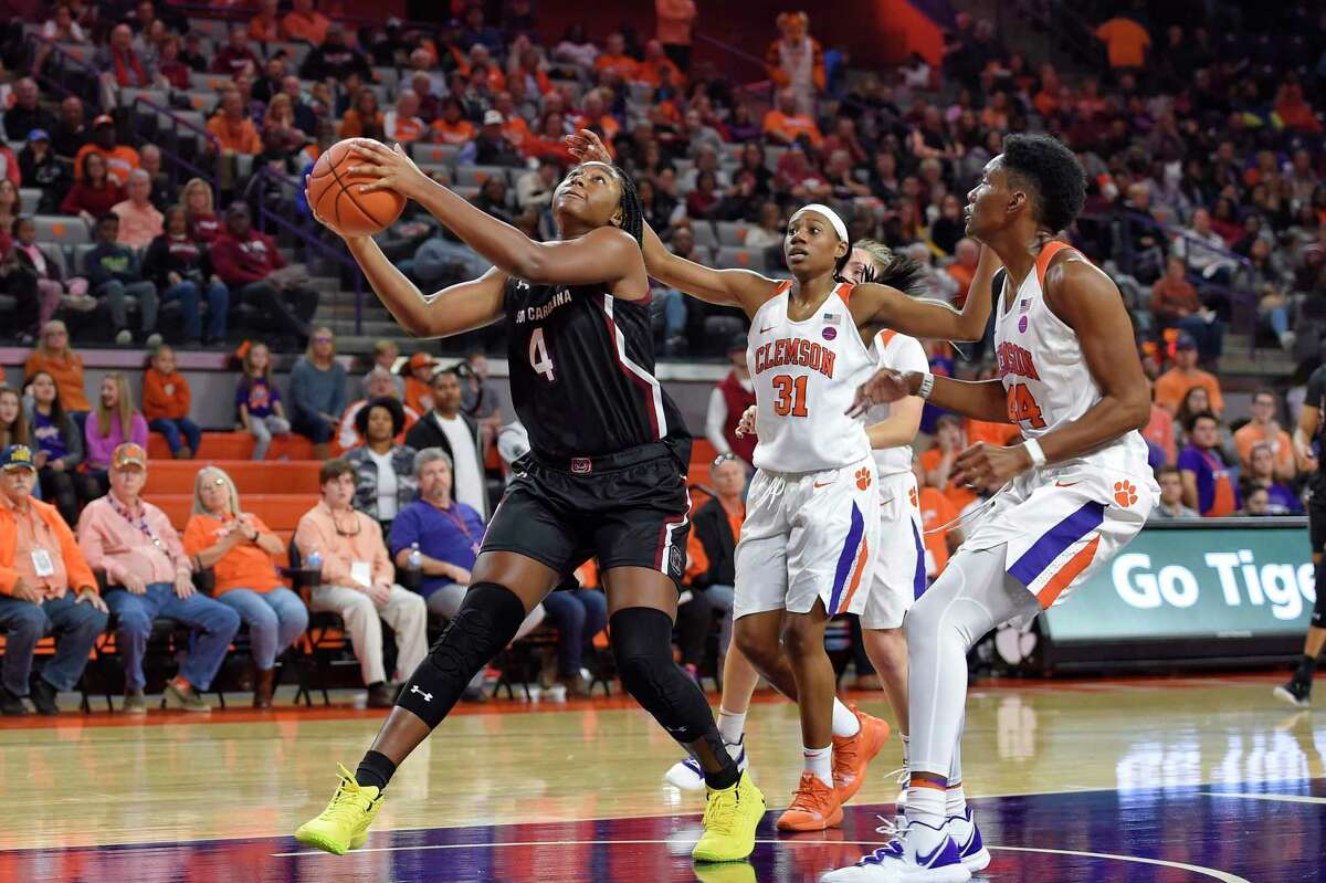 South Carolina's Aliyah Boston (4) grabs the ball while defended by Clemson's Shania Meertens (31) and Kobi Thorton during the first half of an NCAA college basketball game Sunday, Nov. 24, 2019, in Clemson, S.C. (AP Photo/Richard Shiro)