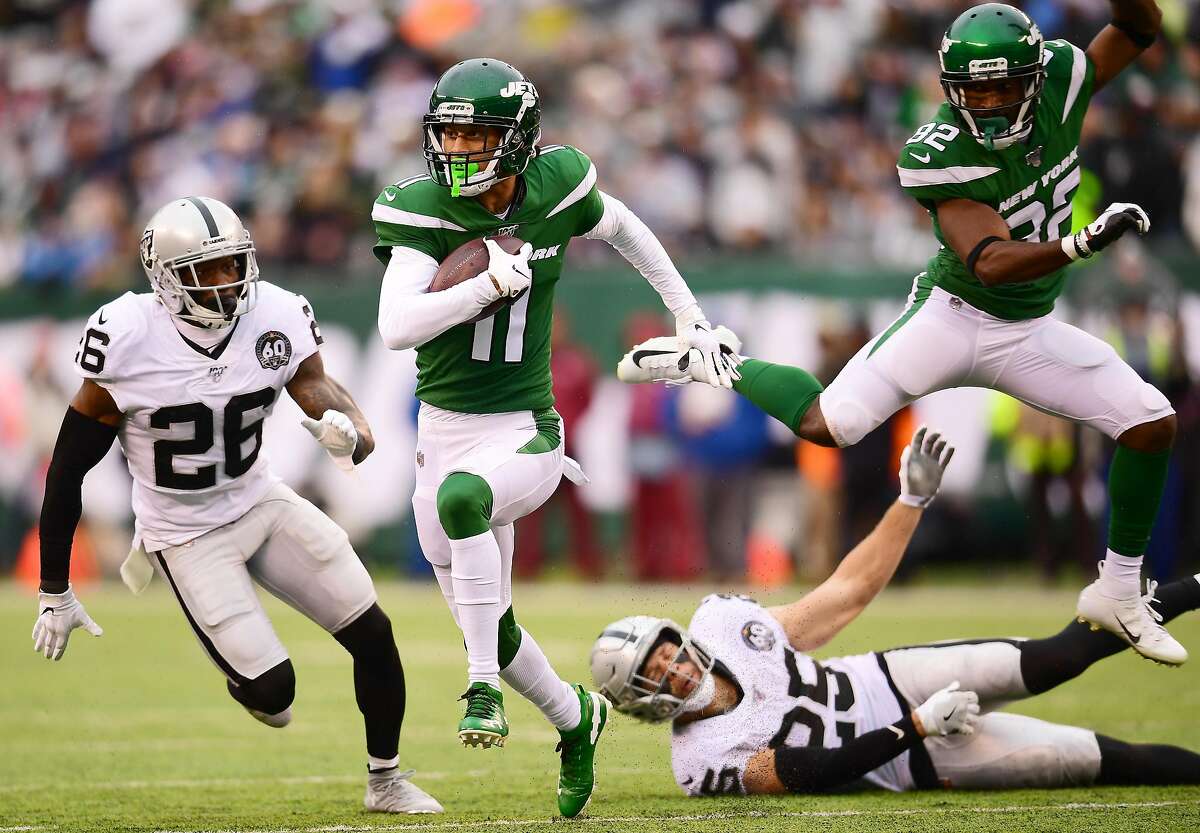 EAST RUTHERFORD, NEW JERSEY - NOVEMBER 24: Robby Anderson #11 of the New York Jets carries the ball past Erik Harris #25 and Nevin Lawson #26 of the Oakland Raiders during the second quarter of their game at MetLife Stadium on November 24, 2019 in East Rutherford, New Jersey. (Photo by Emilee Chinn/Getty Images)