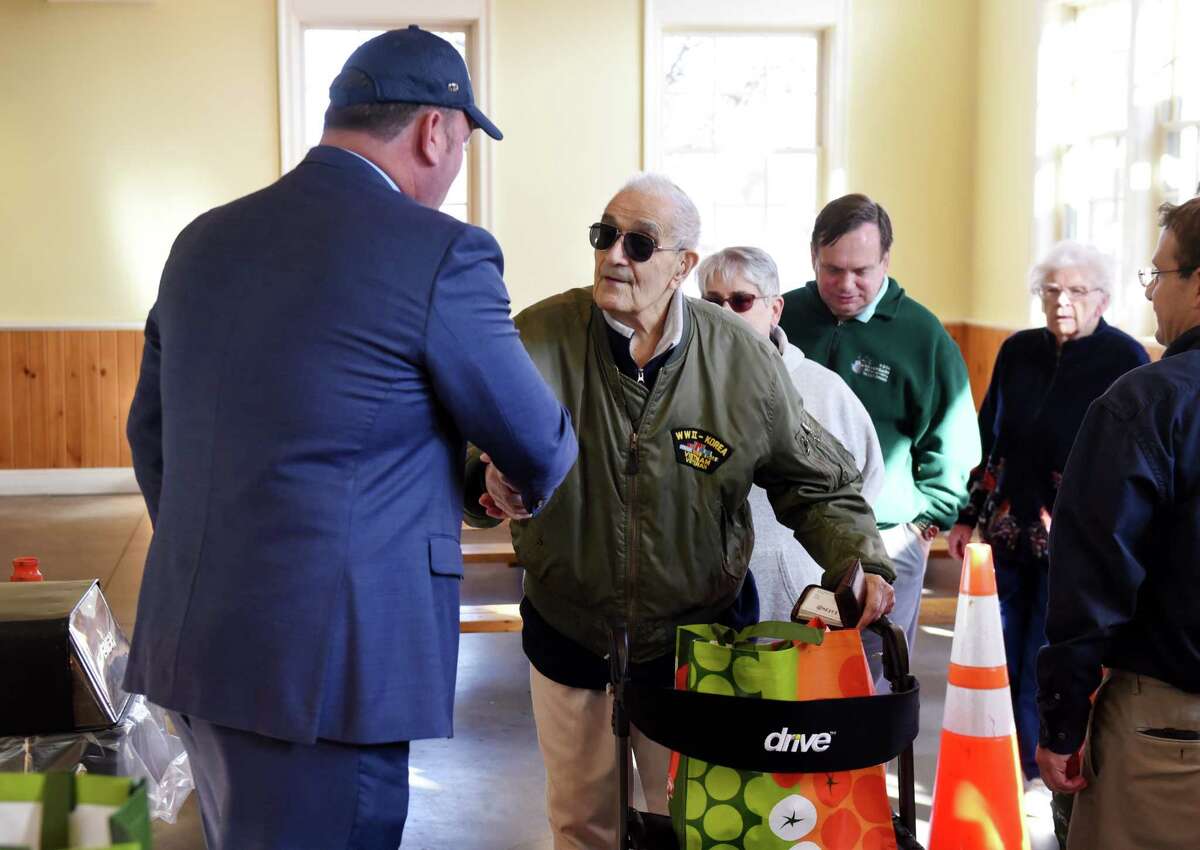 U.S. Army veteran Brad Van Ornam, 92, receives a Thanksgiving turkey from Matthew Tully, founding partner of Tully Rinckey PLLC, during the legal firm's 11th annual Turkeys for Veterans program event on Tuesday, Nov. 26, 2019, at The Crossing of Colonie in Colonie, N.Y. Van Ornam survived three conflicts during his 22 years of service. Free turkeys were available for local active duty and retired military personnel. (Will Waldron/Times Union)