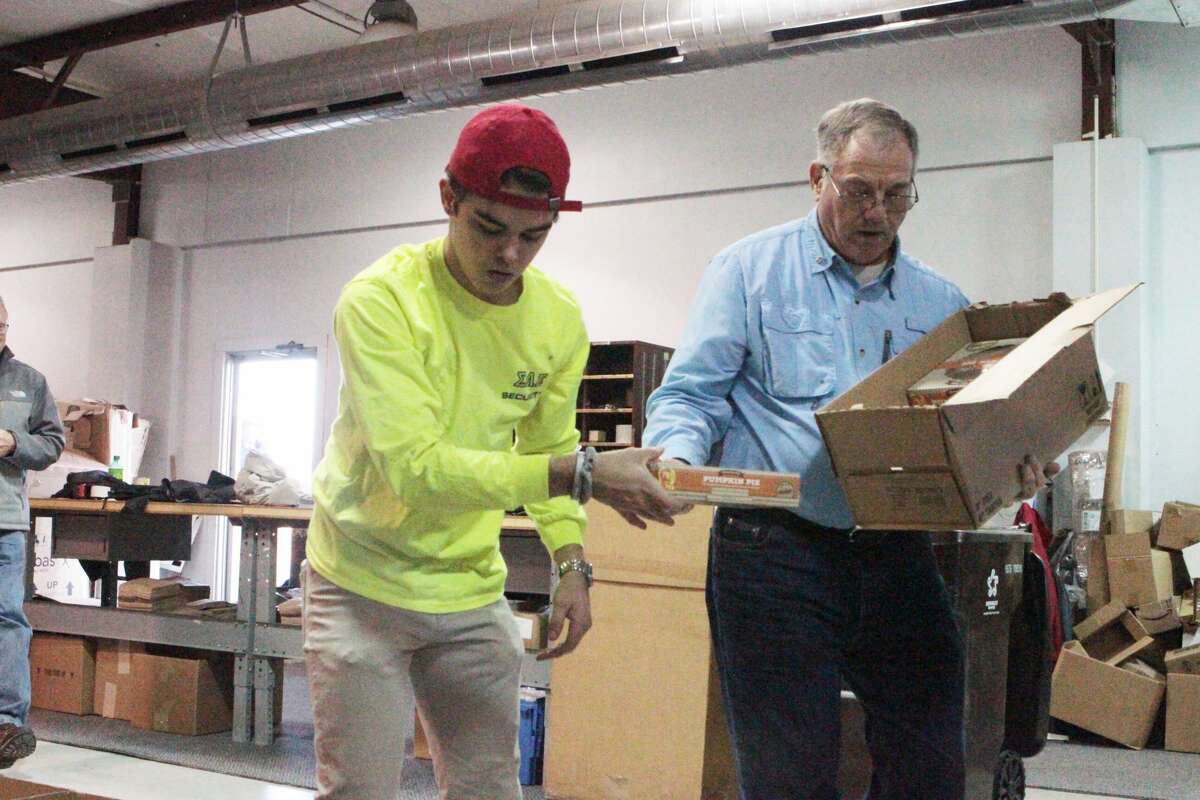 Volunteers with the Rotary Club of Big Rapids and Sigma Alpha Epsilon fraternity from Ferris State University, descended upon the Great Lakes Book and Supply warehouse on Clark Street Tuesday to pack and distribute Thanksgiving care packages for local families.