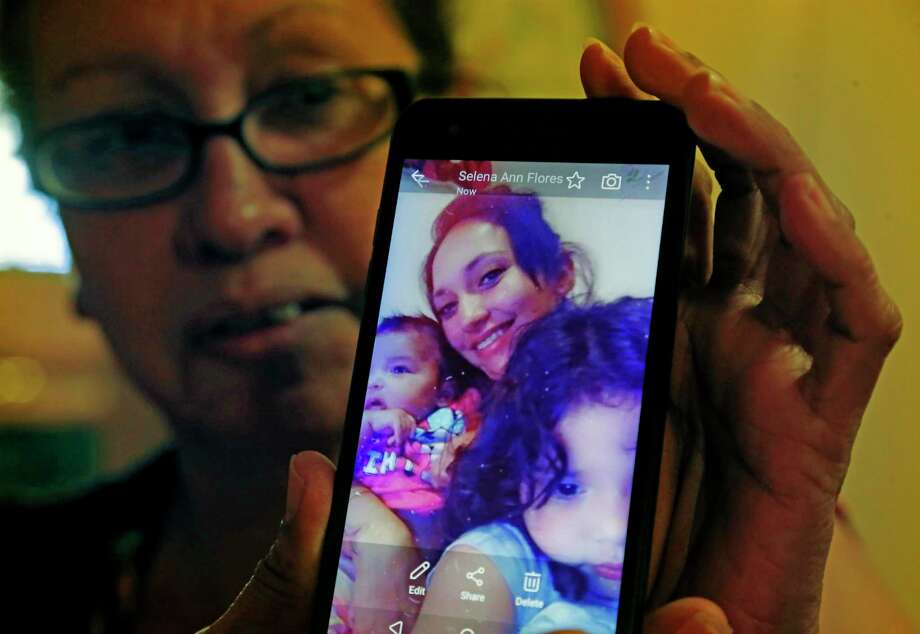 Teresa Garcia holds a image of her daughter Selena Flores with her two children. The Garcias almost lost their apartment after Flores was arrested on a drug charge. She has been removed from the lease and can no longer stay or visit her children at the apartment. Photo: Ronald Cortes / 2019 Ronald Cortes