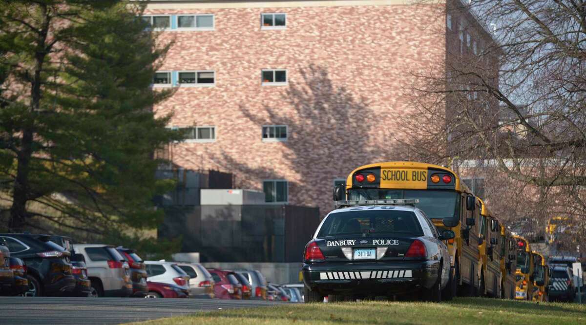 Police cruisers sit at Danbury High School on Monday.