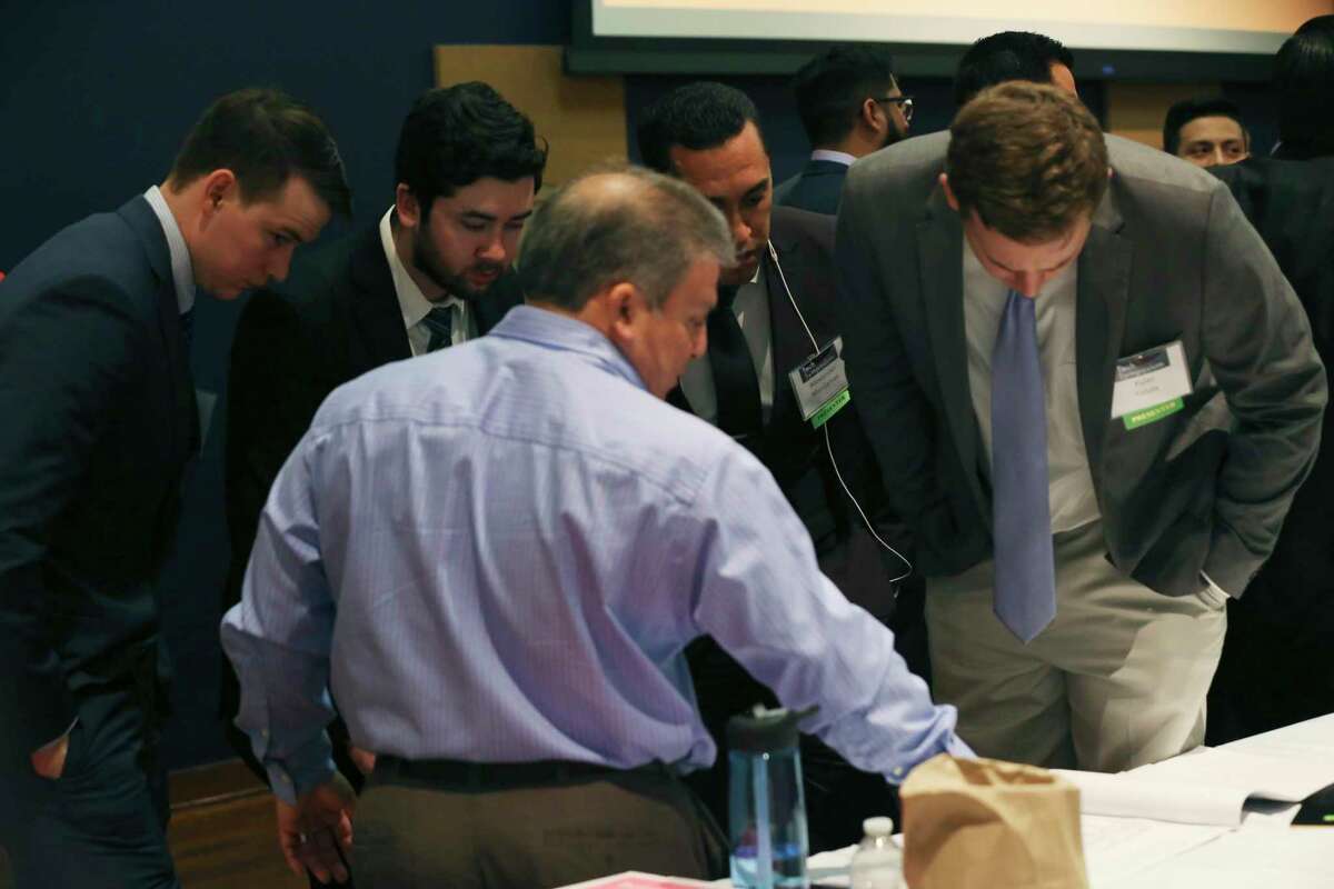 Civil engineering undergraduate students, from left, Conner Murphy, 22, and Tyler Surles, 22, both from Houston, Alexander Manjarres, 27, of San Antonio and Kyler Felux, 23, of Poth, listen as alumnus Damien Herrera offers advice during the University of Texas at San Antonio Fall 2019 Tech Symposium on Tuesday. The team designed construction of a restaurant site.