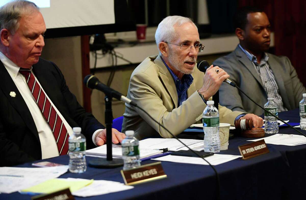 Board of Education Chairman Bruce Kimmel, center, submitted his resignation on Monday.