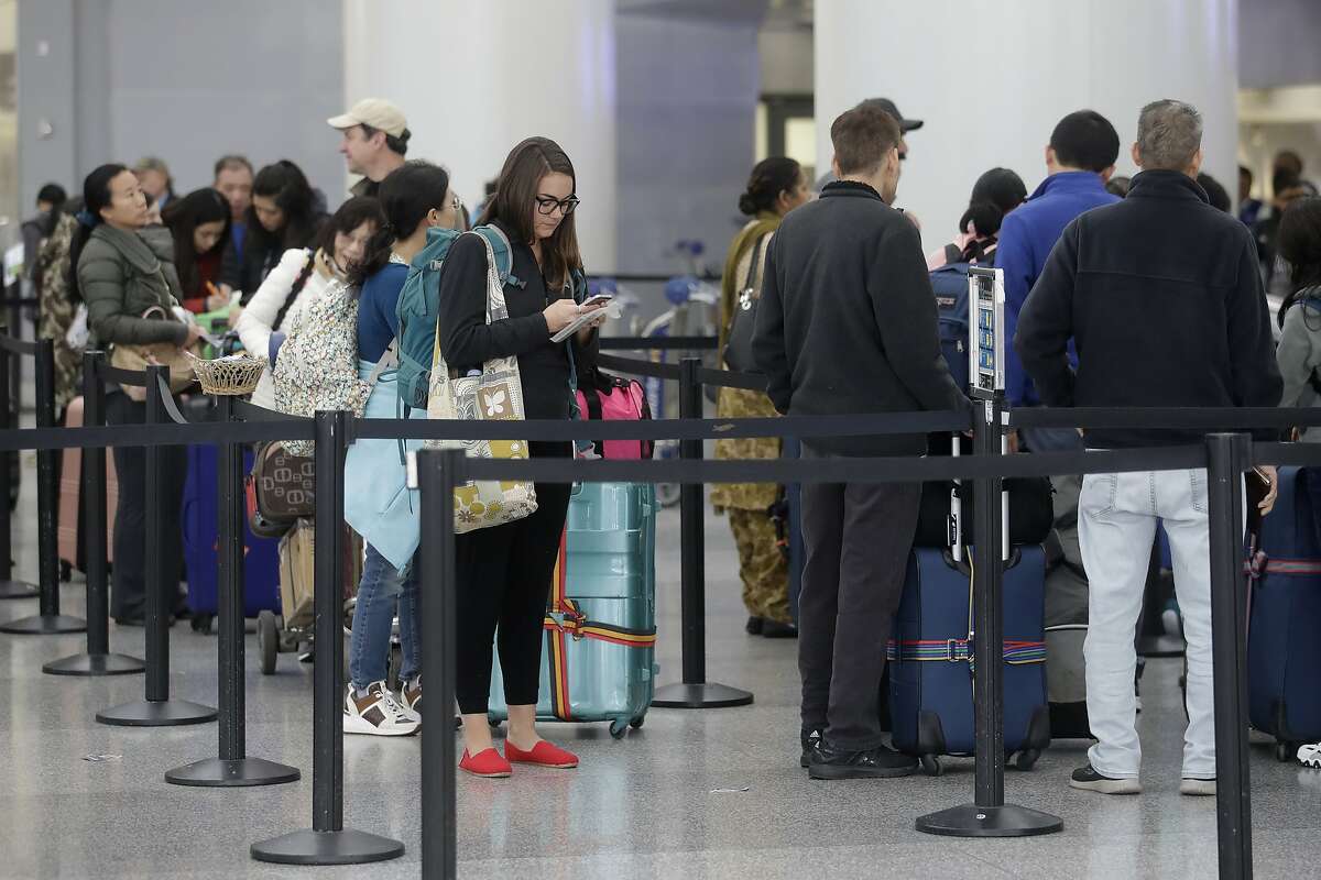 Travelers wait to pass through security gates at San Francisco International Airport in San Francisco, Tuesday, Nov. 26, 2019. (AP Photo/Jeff Chiu)