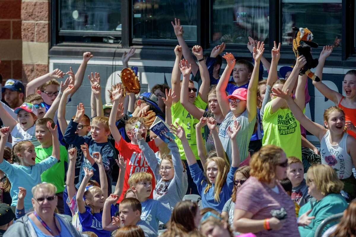 FILE - In this April 11, 2018, file photo, school children cheer as the West Virginia Power face the Lakewood BlueClaws at Appalachian Power Park, in Charleston, W.V. Major League Baseball is pushing a proposal to eliminate 42 teams — and several entire leagues — from its vast network of minor-league affiliates that bring the game to every corner of country. At the same time, Minor League Baseball has announced that it will partner with Stamford-based Octagon on a media-distribution strategy.
