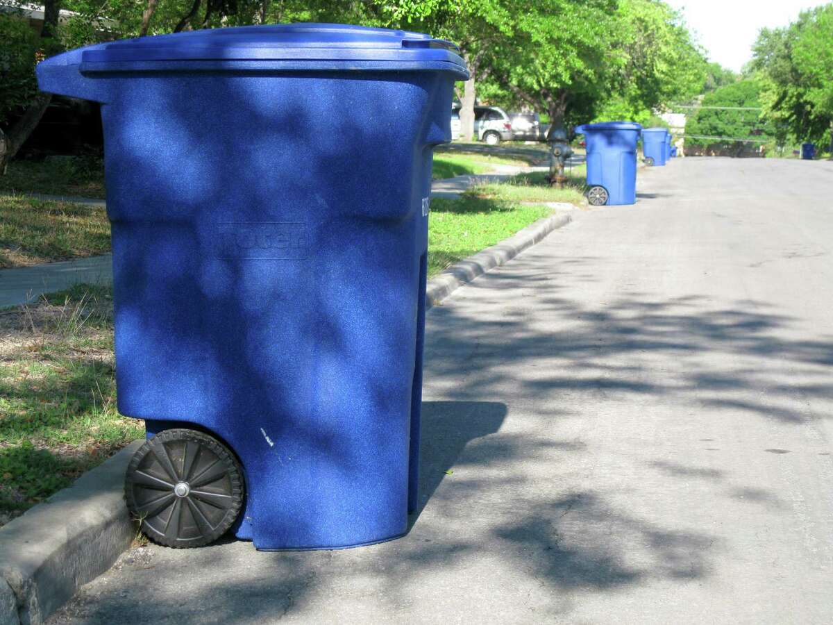 A 96-gallon recycling bin waits by the curb for pickup
