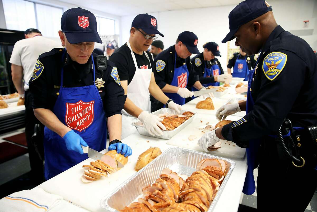 Deputy Chief David Lazar, left, and Commander Steven Ford, both with the San Francisco Police Department, carve turkey breasts during the Salvation Army's annual turkey carving event in San Francisco, Calif., on Wednesday, November 27, 2019. Approximately 1,600 pounds of turkey was carved up to serve in various Salvation Army Thanksgiving Day dinner events on Thursday.