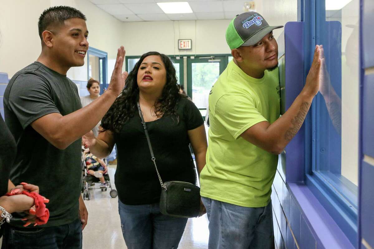 Lorenzo Rodriguez, from right, Sabrina Ruiz and Alex Ruiz look through a window into a classroom at Gardendale Elementary School on the first day of school last August. Edgewood ISD has partnered with the city's Pre-K 4 SA to turn the school into an early education center. Other school districts also are expanding preschool offerings. Eligibility to most public programs is based on household income, leaving access for middle class families a continuing problem.