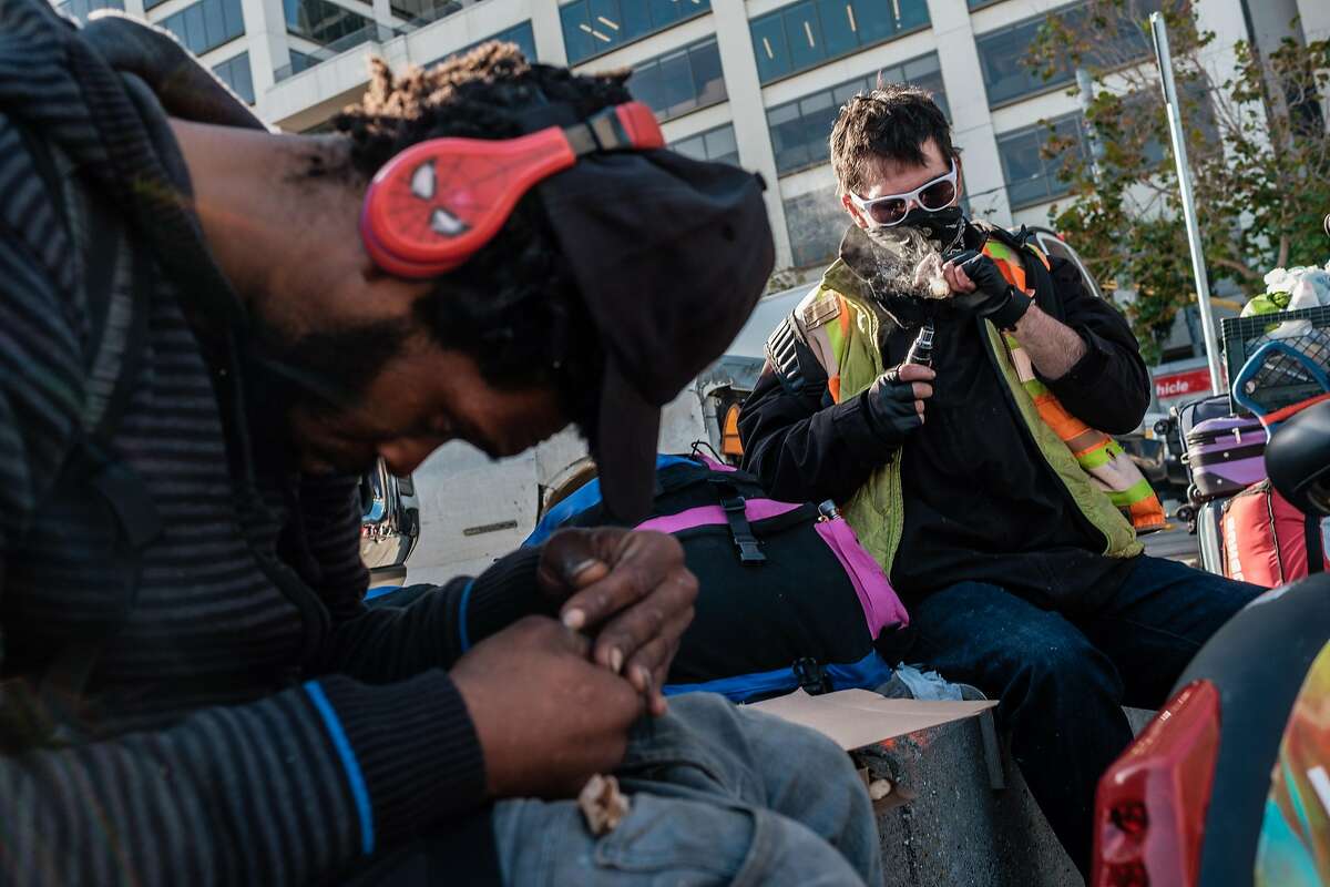 A man who goes by the name Country, right, smokes meth on the plaza near the Embarcadero in San Francisco, Calif. on Thursday, November 21, 2019.