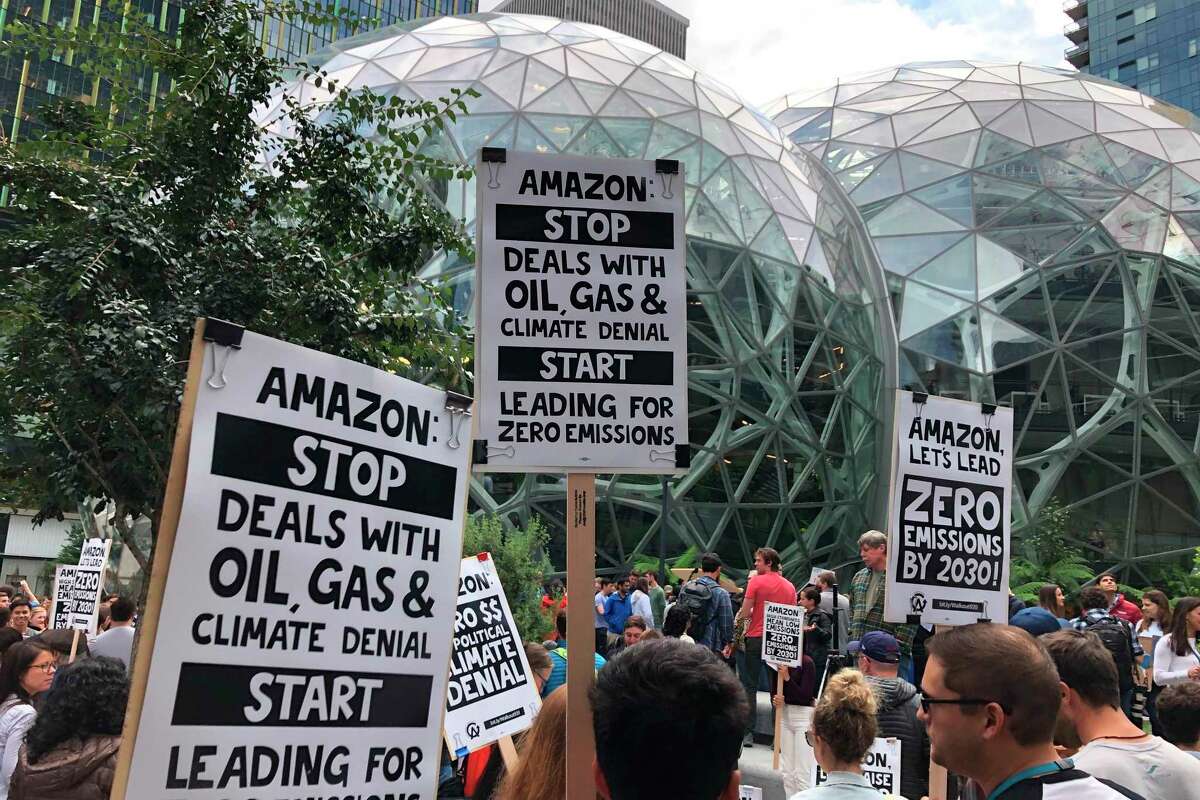FILE - In this Friday, Sept. 20, 2019 file photo, Amazon workers begin to gather in front of the Spheres, participating in the climate strike in Seattle. Employee activism and outside pressure have pushed big tech companies like Amazon, Microsoft and Google promising to slash their carbon emissions. Microsoft and other tech giants have been competing to strike lucrative partnerships with ExxonMobil, Chevron, Shell, BP and other energy firms. (AP Photo/Elaine Thompson, File)
