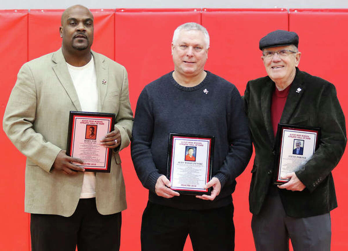 Alton High athletics recognized its 2019 Hall of Fame class at halftime of the Redbirds’ boys basketball victory over St. Louis Carnahan in the Redbirds’ Tip-Off Tournament at Alton High on Wednesday night. Inductees (from left) 1997 graduate and three-sport athlete Rory Fox (football, basketball and baseball), former boys and girls bowling coach Jeff Woszczynski and retired Telegraph sports writer Steve Porter (1973-2013) pose with their Hall of Fame plaques. The 1935 Redbirds football team that went 9-0 was also welcomed into the AHS Hall.