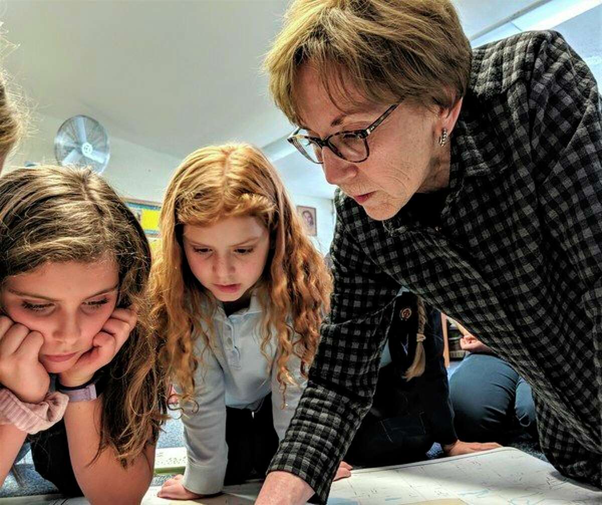 From left, Blessed Sacrament students Brynn Haddad and Lindsay Hofmeister watch attentively as Midland Mayor Maureen Donker, points out the different wards on a map of the city. (Photo provided)
