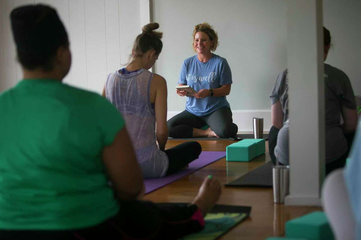 Stephanie Konvicka reads "When We Breathe Together" from the book "Circle of Grace" by Jan Richardson during a yoga session on Wednesday, Aug. 28, 2019, in Wharton, TX. Many homes in Wharton were devastated by floods from Hurricane Harvey and residents are still wading through federal and state aid paperwork to rebuild their homes and lives. Konvicka offers yoga classes to support and empower the people of Wharton.
