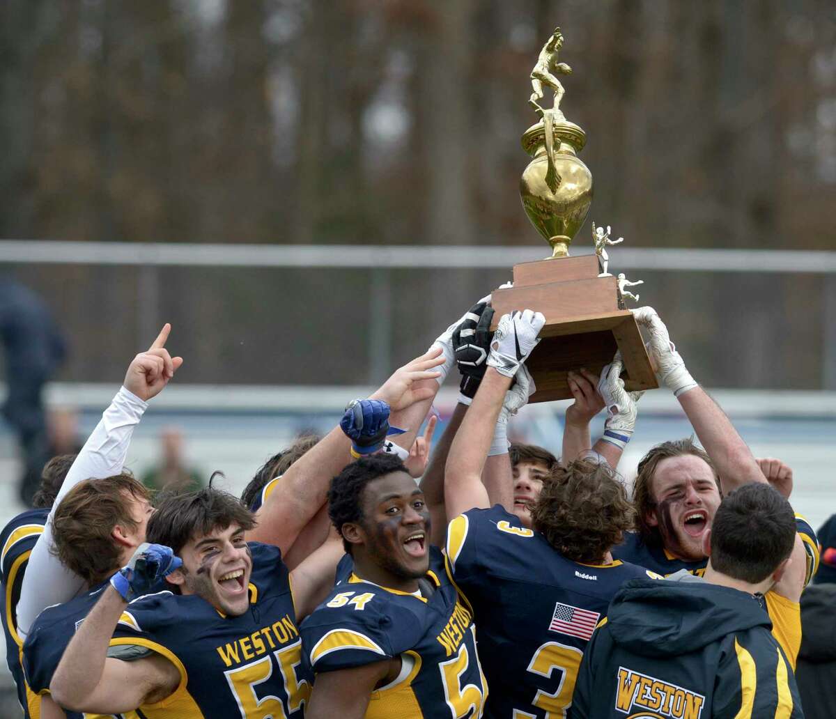 Weston seniors hold the trophy after winning the Thanksgiving football game between Joel Barlow and Weston high schools. Thursday, November 28, 2019, at Weston High School, Weston, Conn.