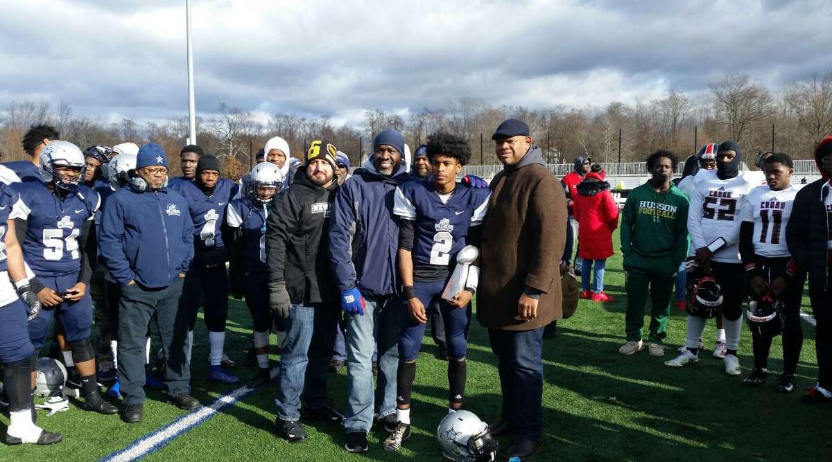 Hillhouse QB Demelle Turner (No. 2) receives trophy for offensive MVP  after scoring 4 TDs to lead Hillhouse to a 37-0 win over Wilbur Cross Thursday.