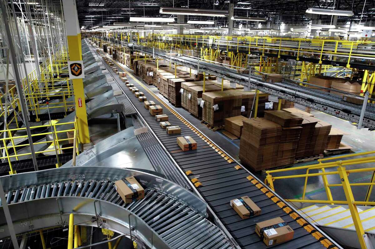 FILE- In this Aug. 3, 2017, file photo, packages ride on a conveyor system at an Amazon fulfillment center in Baltimore. Amazon, Walmart and others are promising to deliver more of their goods in a day and this holiday season will be the first real test of whether they can make that happen. (AP Photo/Patrick Semansky, File)