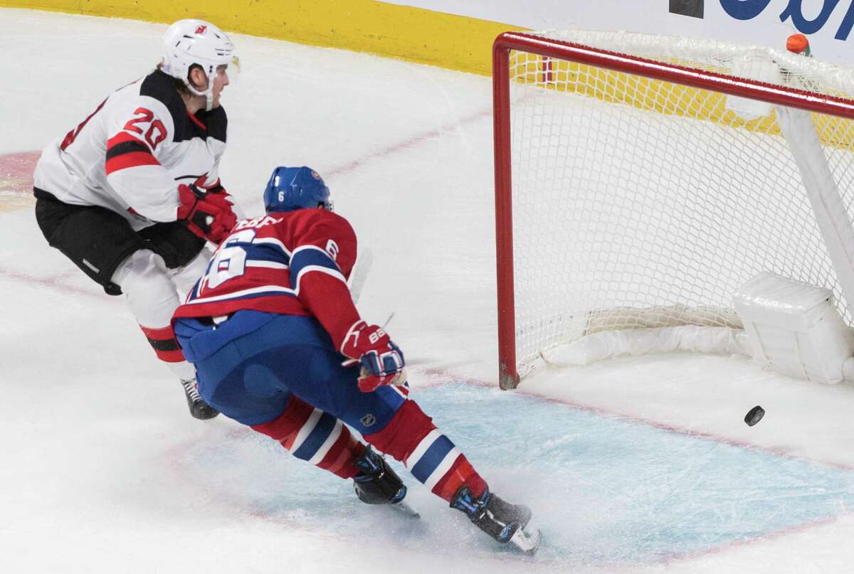 New Jersey Devils' Blake Coleman (20) scores on an empty net as Montreal Canadiens' Shea Weber defends during third-period NHL hockey game action in Montreal, Thursday, Nov. 28, 2019. (Graham Hughes/The Canadian Press via AP)