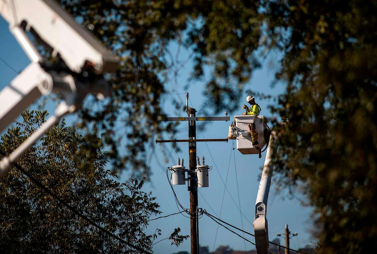A PG&E contractor works on utility poles along Highway 128 near Geyserville, California on October 31, 2019. (Photo by Philip Pacheco / AFP) (Photo by PHILIP PACHECO/AFP via Getty Images)