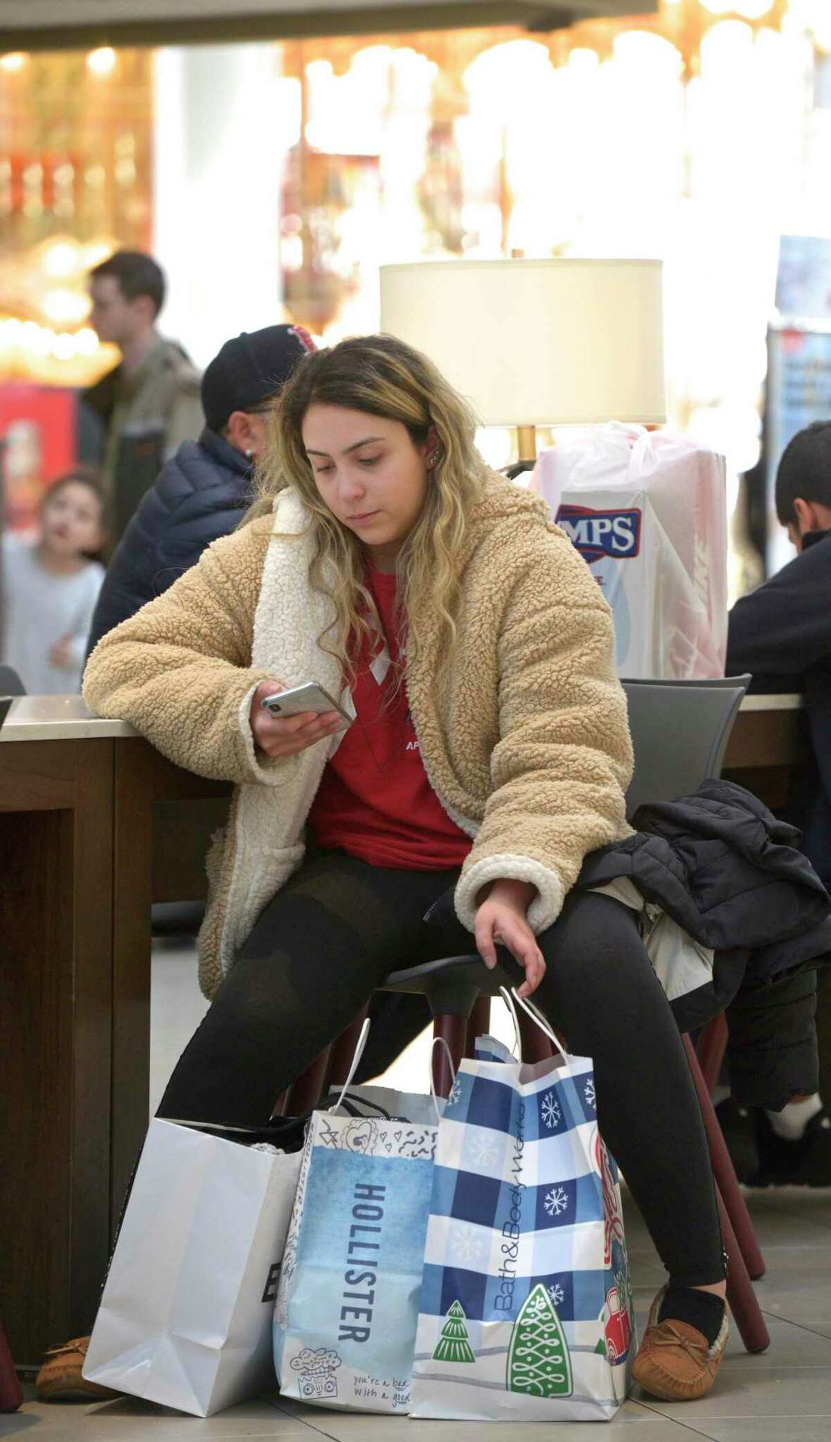 Vanessa Silva, of Brewster, takes a break from her Black Friday shopping at the Danbury Fair mall, on Friday, November 29, 2019, in Danbury, Conn. Silva got to the mall at 6 AM to shop.