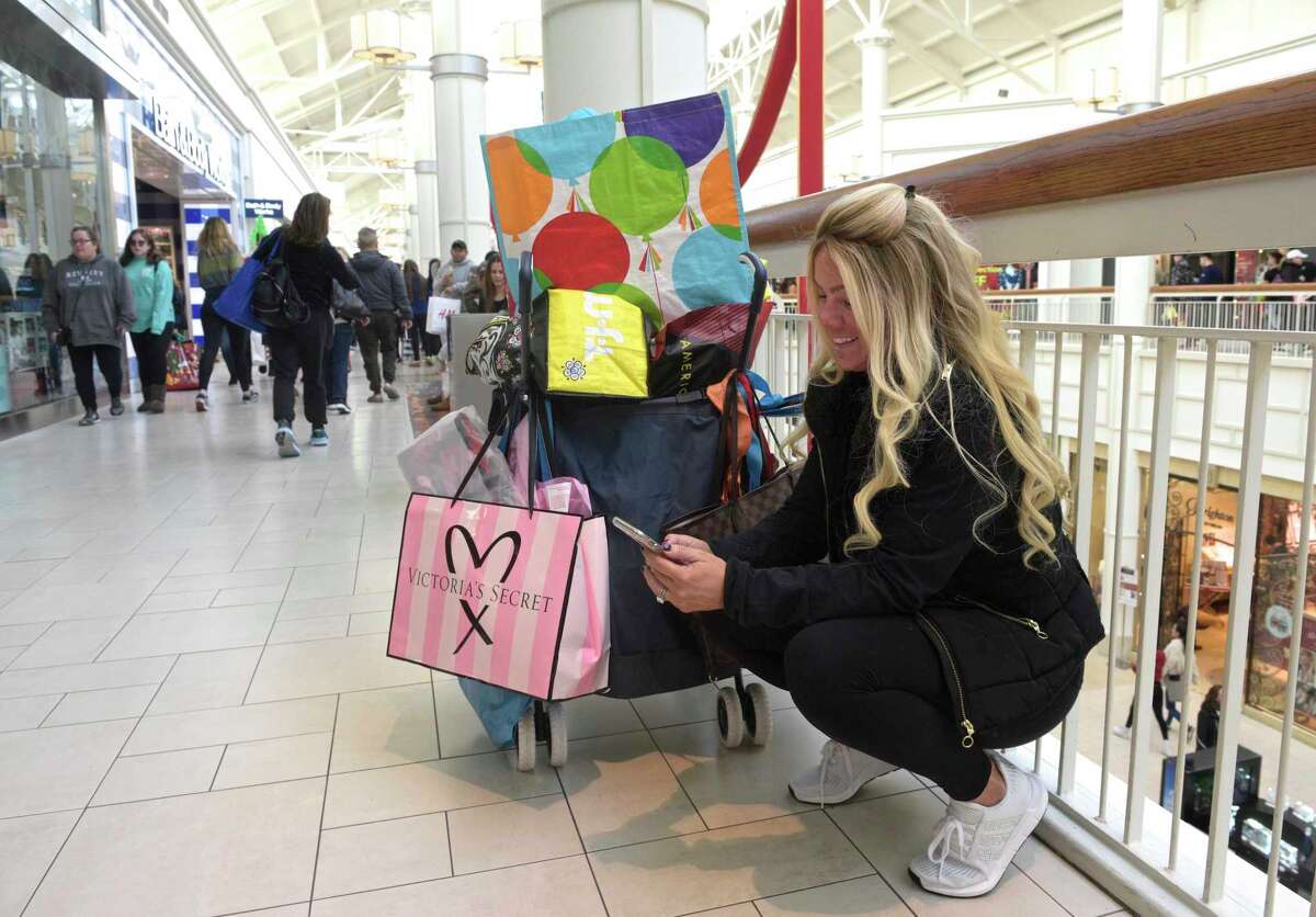 Rosalie Passiatore, of Ossining, NY, checks her phone while Black Friday shopping at the Danbury Fair mall. Passiatore has a yearly tradition of shopping with her mother, two sisters and an aunt on black Friday, they ever have special t-shirts they wear. Friday, November 29, 2019, in Danbury, Conn.