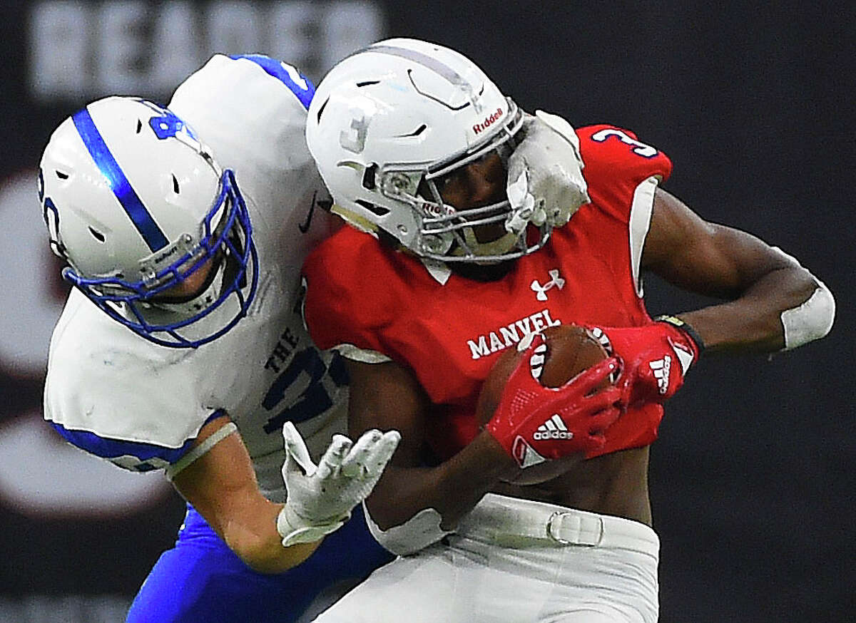 Manvel wide receiver Jalen Walthall, right, is tackled by Barbers Hill defensive back Josh Bishop during the second half of a 5A Division II regional high school football playoff game, Friday, Nov. 29, 2019, in Houston.
