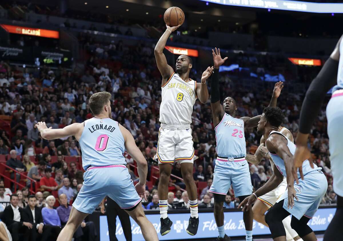 Golden State Warriors guard Alec Burks (8) shoots over Miami Heat forward Meyers Leonard (0) and guard Kendrick Nunn (25) during the first half of an NBA basketball game, Friday, Nov. 29, 2019, in Miami. (AP Photo/Lynne Sladky)