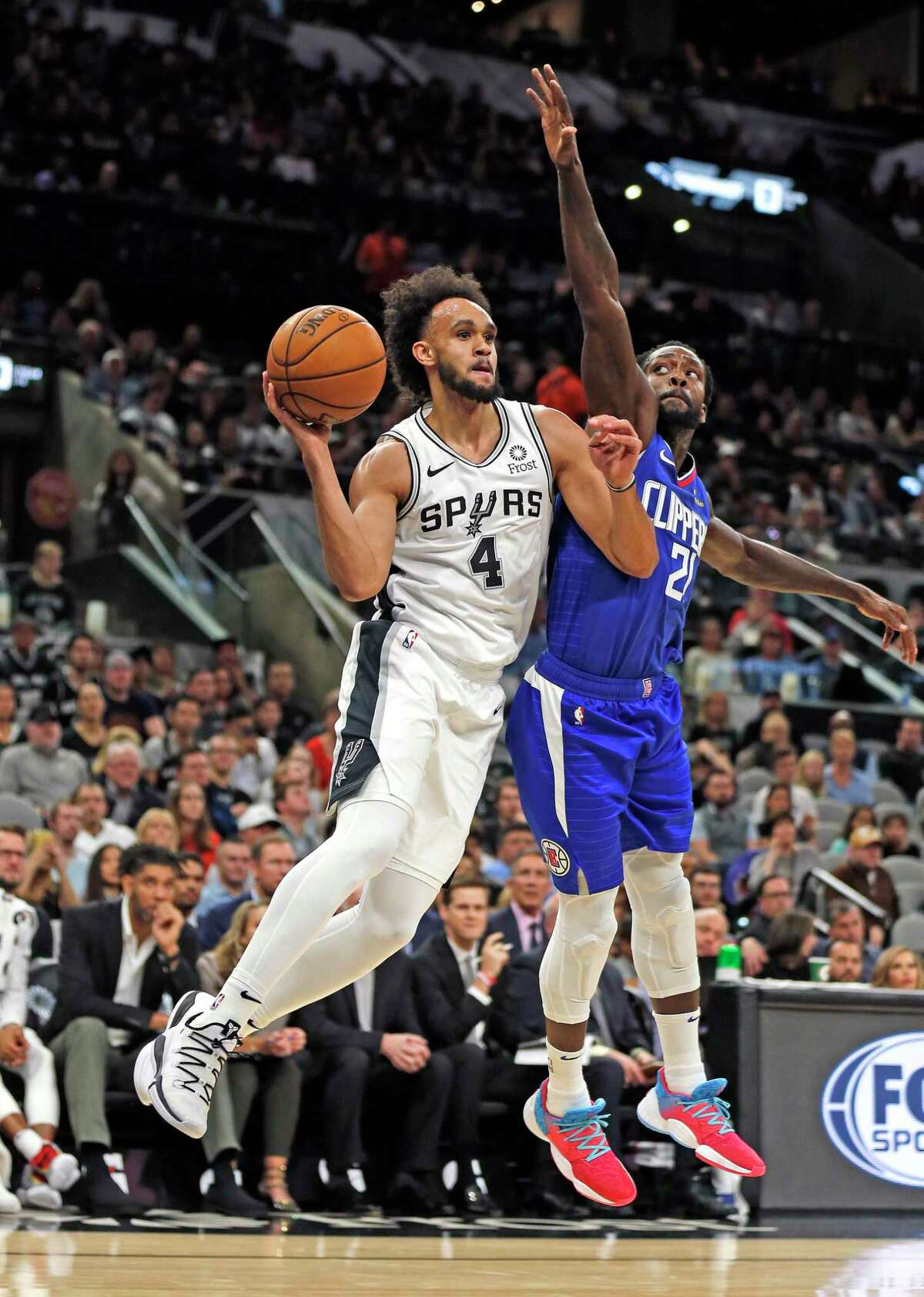 Derrick White #4 of the San Antonio Spurs passes off after being guarded by Kawhi Leonard #2 #2 of the Los Angeles Clippers in the first half of the game between the San Antonio Spurs and the Los Angeles Clippers on Friday, November 29,2019 at AT&T Center