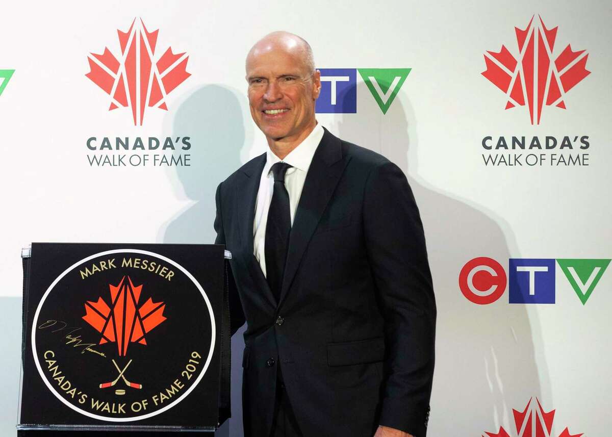 Hockey great Mark Messier stands next to his star as he is inducted into Canada's Walk of Fame, in Toronto on Nov. 23, 2019.