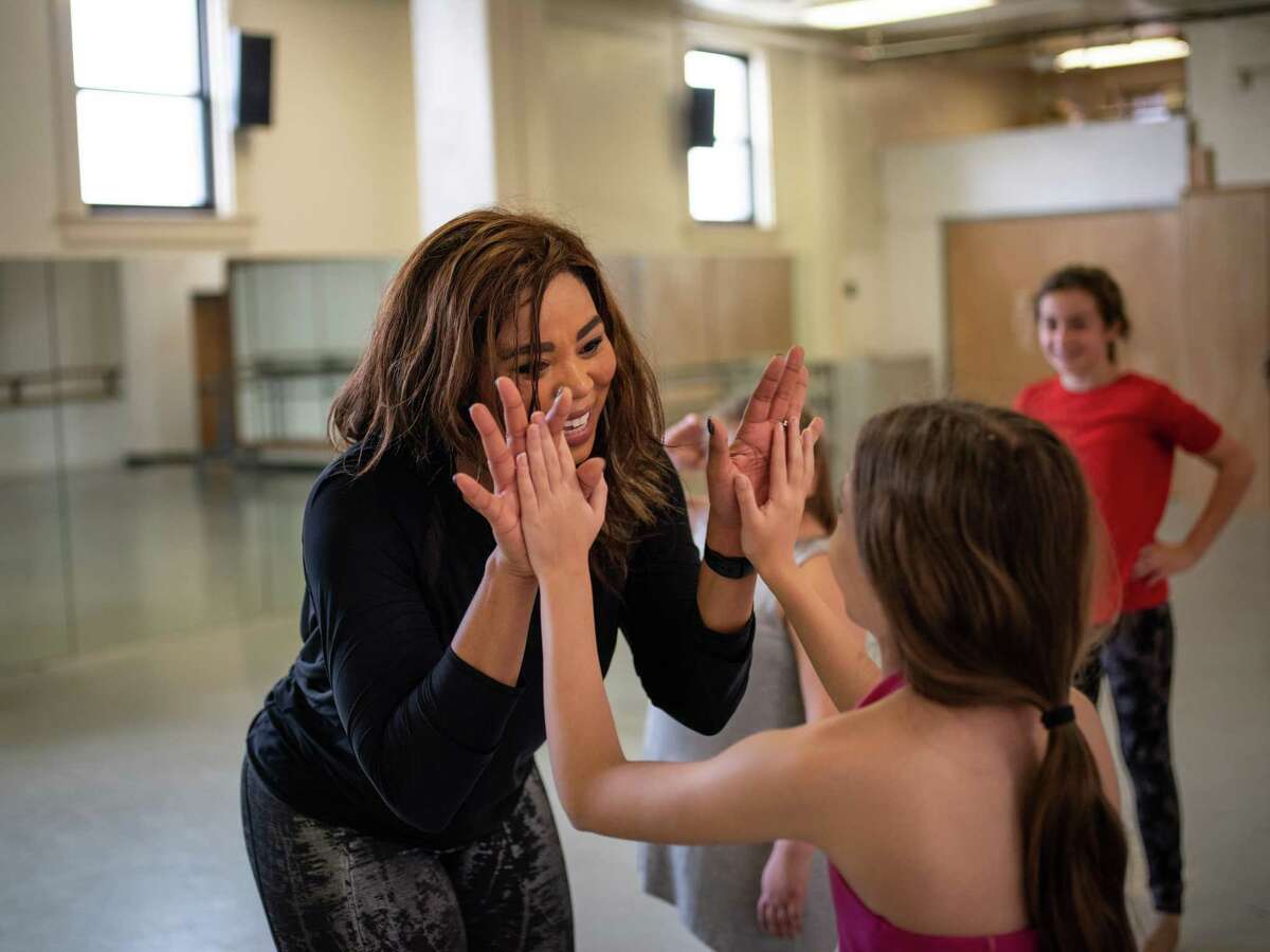 Woodford high fives a young dancer she is teaching Saturday.
