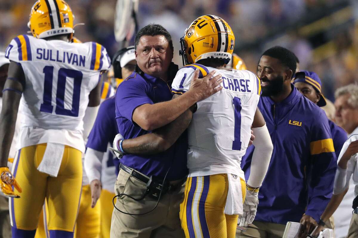 LSU coach Ed Orgeron hugs wide receiver Ja'Marr Chase (1) on the sideline after his touchdown reception in the first half of an NCAA college football game against Texas A&M in Baton Rouge, La., Saturday, Nov. 30, 2019. (AP Photo/Gerald Herbert)