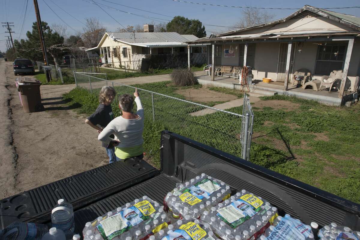 FILE: Donna Johnson and Becky Keck (L) talk as Johnson brings her water during her deliveries of donated drinking water to neighborhood households as water wells supplying hundreds of residents remain dry in the fourth year of worsening drought on February 11, 2015 in East Porterville, California. Many local residents fill water tanks with free non-potable water for flushing toilets, bathing and laundering. Bottled water is used for drinking, cooking and washing dishes. Most of the wells of about 926 dry homes in Tulare County stopped flowing last summer when some 17 California communities ran out of water. (Photo by David McNew/Getty Images)