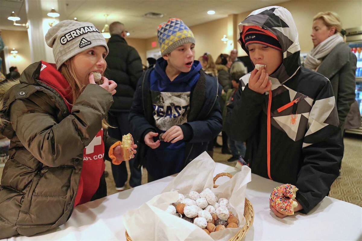 Doughnut samplers from left are twins Josephine and Lucas Lewertoff, 11, of Westport, and Lucas Gomez, 10, of Norwalk at the Saugatuck Bridge Lighting Holiday Festival at the Saugatuck Rowing Club on Friday, Nov. 29, 2019, in Westport, Conn.