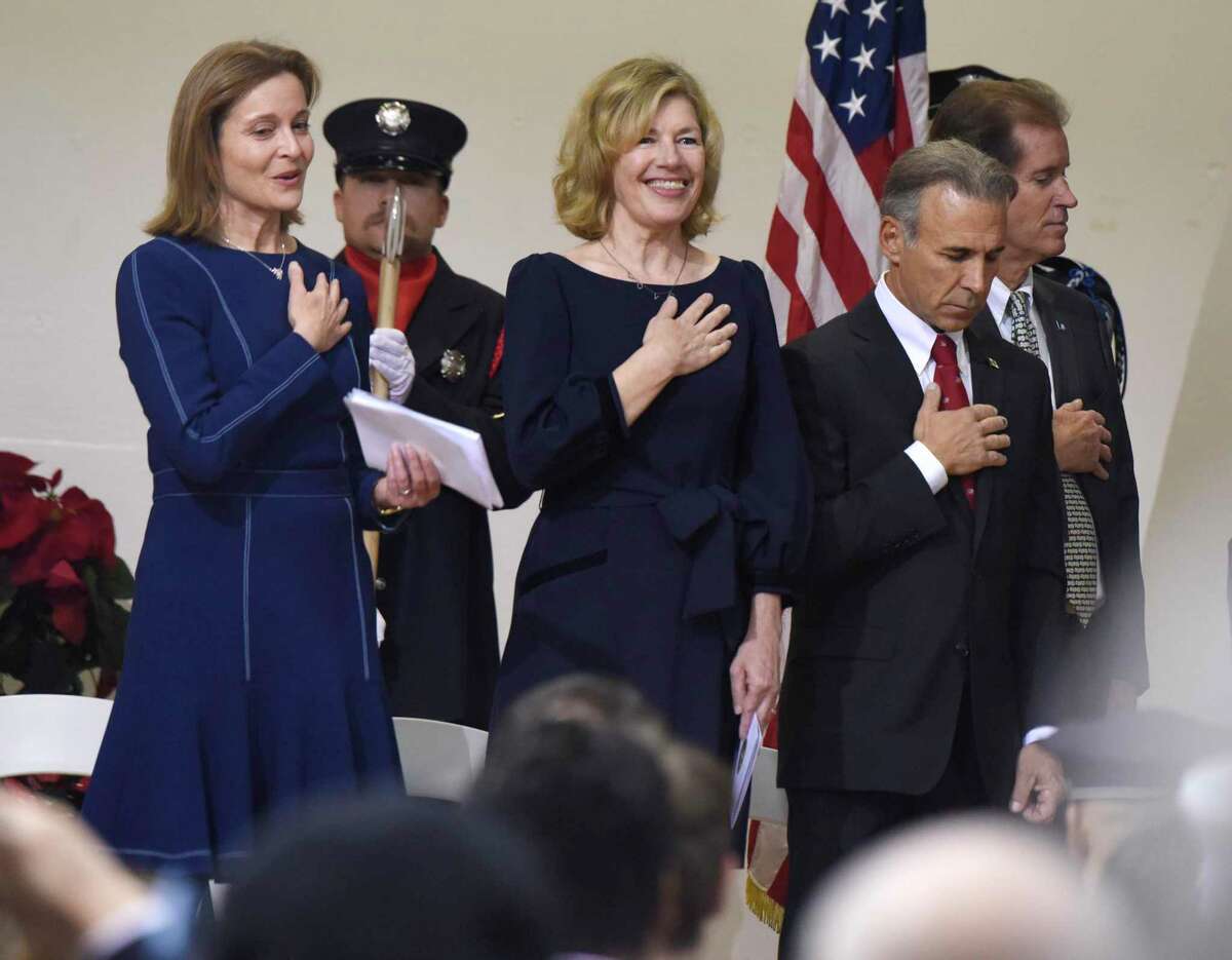 Selectwoman Jill Oberlander, left, Selectwoman Lauren Rabin, center, and First Selectman Fred Camillo put their hands over their hearts during the National Anthem at the Board of Selectmen swearing-in ceremony at the Boys & Girls Club of Greenwich in Greenwich, Conn. Sunday, Dec. 1, 2019. Republican Fred Camillo was sworn in as First Selectman, while fellow Republican Lauren Rabin and Democrat Jill Oberlander were sworn in as Selectwomen.