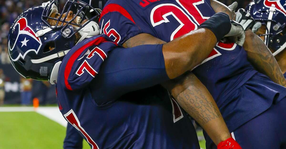 Houston Texans running back Duke Johnson (25) is picked up by Houston Texans offensive tackle Chris Clark (77) after running the ball into the end zone on a 14-yard touchdown pass from Houston Texans quarterback Deshaun Watson (4) during the first quarter of an NFL football game at NRG Stadium on Sunday, Dec. 1, 2019, in Houston.