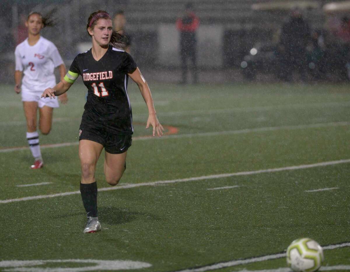 Ridgefield's Caitlin Slaminko (11) chases down the ball ahead of New Canaan's Sophie Potter (2) in the girls soccer game between New Canaan and Ridgefield high schools on Oct. 7 at Ridgefield High School.