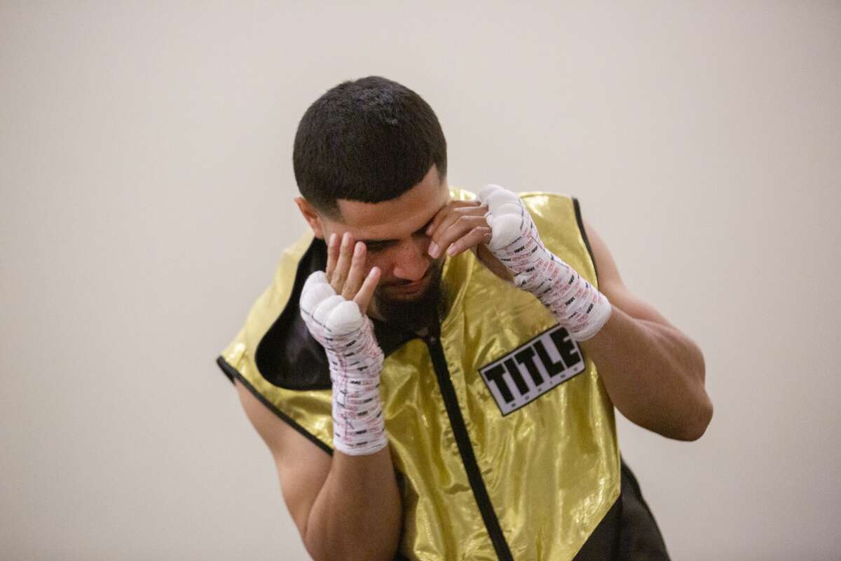 Joseph Rivera, 22, warms up before his boxing match on Nov. 23, 2019, in Houston. It was a big moment for the young fighter, with one of his idols, Evander "The Real Deal" Holyfield, in attendance. It came after a devastating month in which the boxing gym run by Rivera's father was burgled.