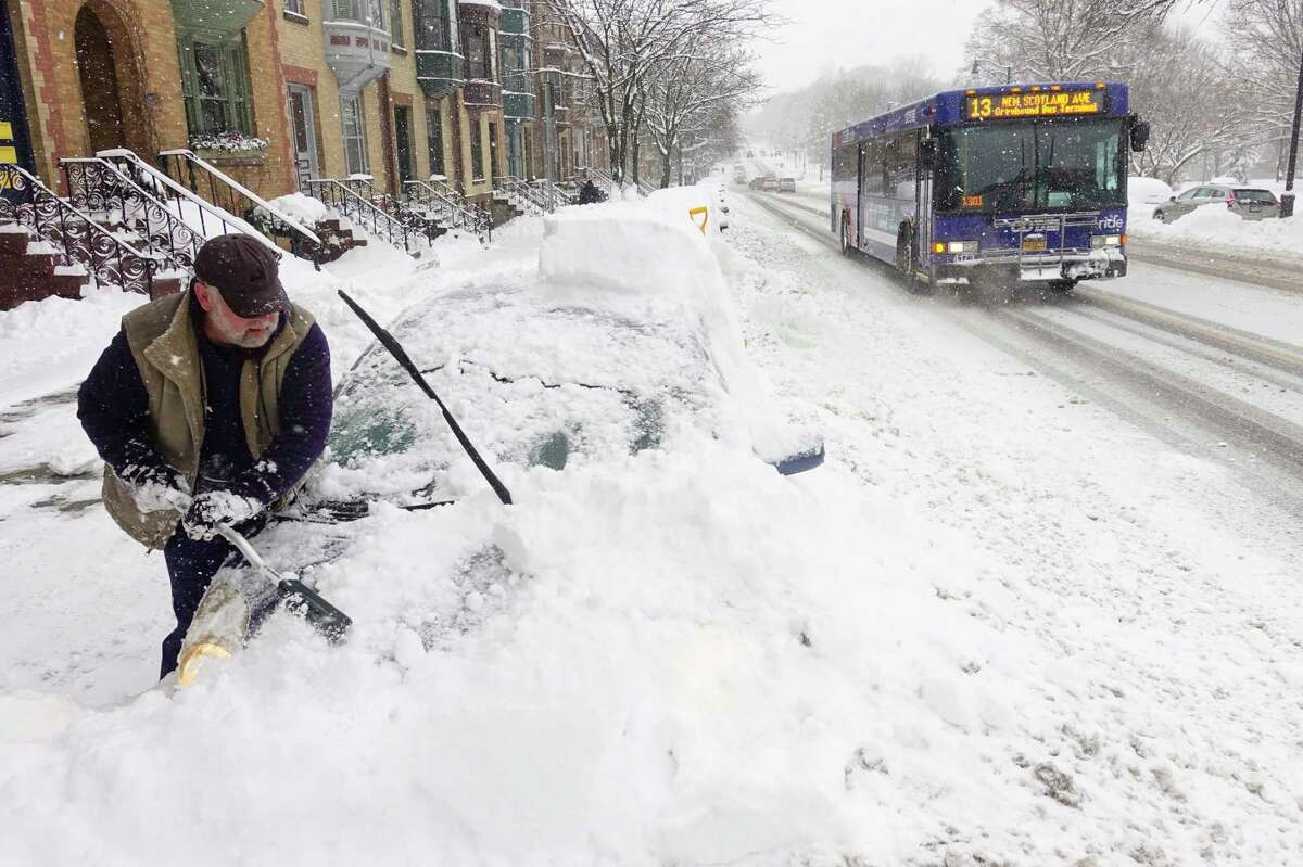 Jack McAvoy of Albany works to clear the snow covering his car on Madison Ave. on Monday, Dec. 2, 2019, in Albany, N.Y. (Paul Buckowski/Times Union)