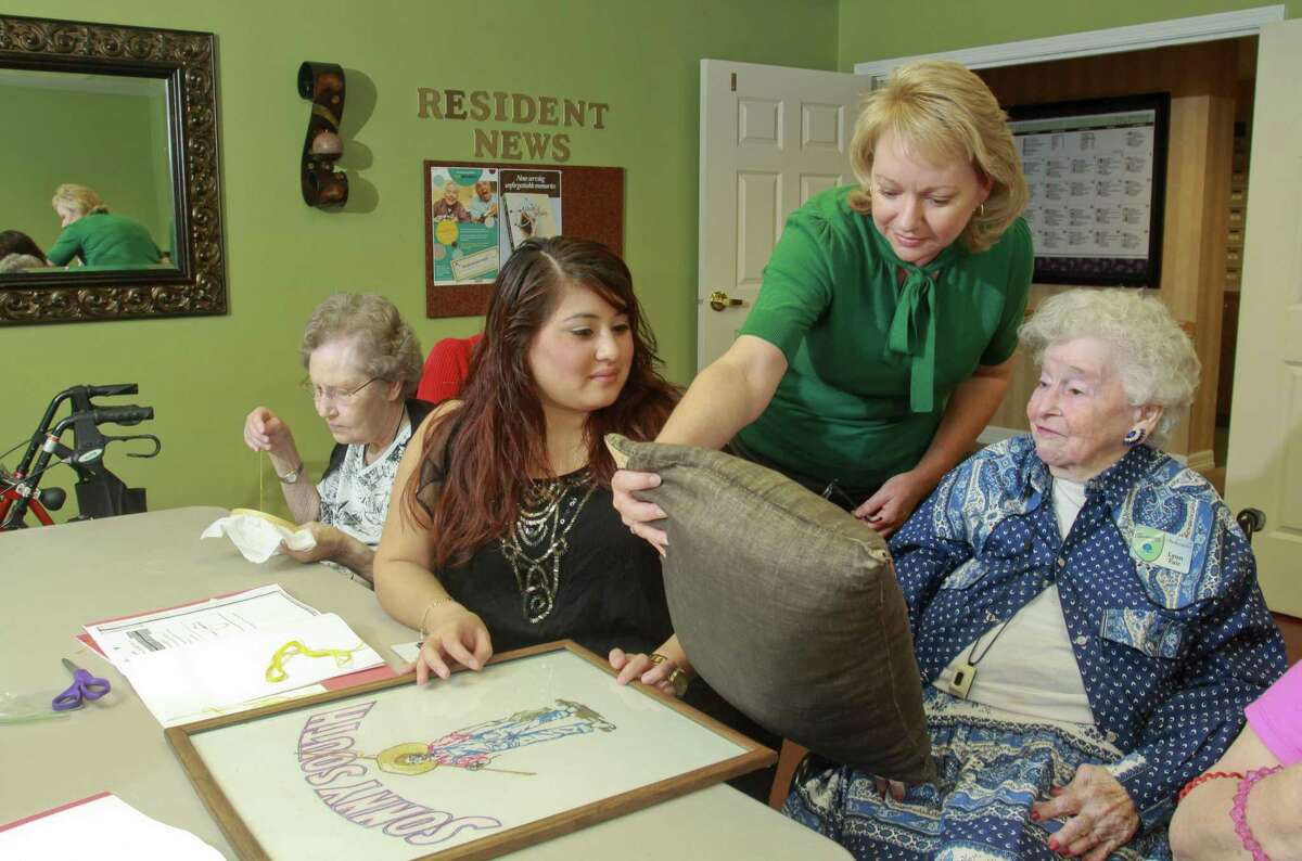 Resident Paula Tideman, from left, Program Specialist Sindy Mejia, Executive Director Kim Parnell, and resident Lynn Fair in an embroidery class at Atria Westchase, a retirement/assisted living facility.