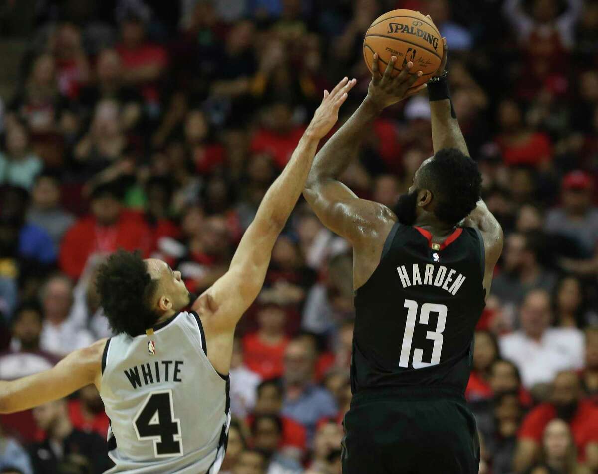 Houston Rockets guard James Harden (13) shoots a three point basket while San Antonio Spurs guard Derrick White (4) is trying to stop him during the third quarter of the NBA game at Toyota Center on Friday, March 22, 2019, in Houston. The Houston Rockets defeated the San Antonio Spurs 111-105.