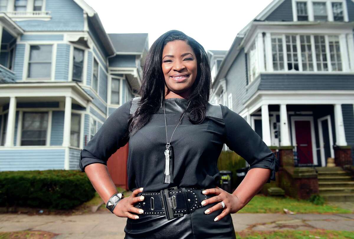 Roberta Hoskie, President and CEO of Outreach Realty Services, is photographed in 2015 in front of the first house she purchased at 283 Norton St. (left) in New Haven.