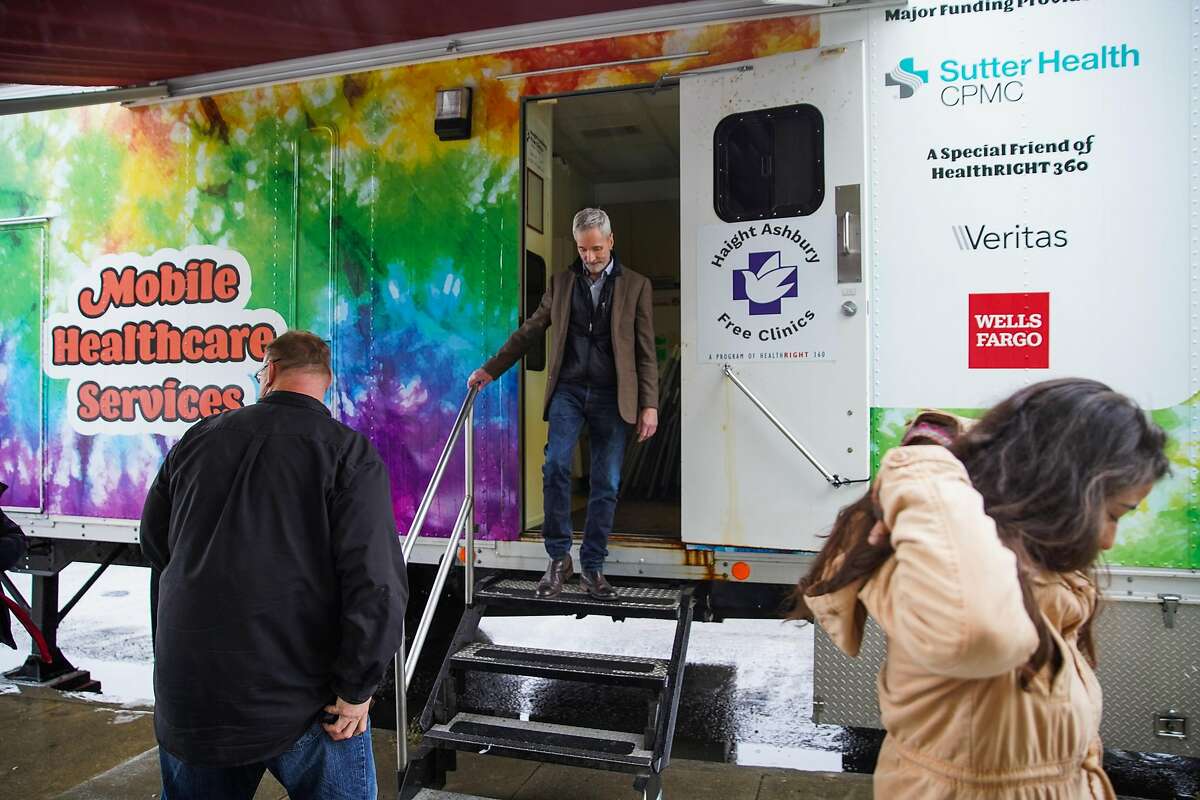 Director of philanthropy Jeff Schindler (center) exits the Health Right 360 mobile services van in San Francisco, California, on Monday, Dec. 2, 2019. The van will be offering addiction treatment services.