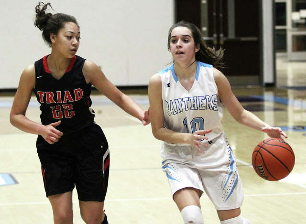 Jersey’s Abby Manns (right), shown driving on Triad’s Alyssa Powell in a game last season in Jerseyville, made three 3-pointers and scored 17 points Monday night in the Panthers’ win over Waterloo in their MVC opener at Jerseyville.
