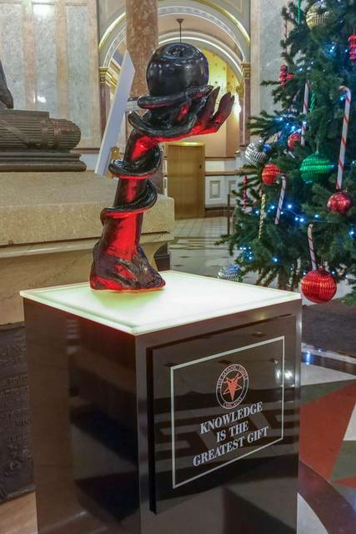 Seasonal decorations are filling the Illinois Capitol rotunda, including a satanic sculpture near a traditional Christmas tree. The winter displays, installed for 30 days, are protected by the First Amendment of the U.S. Constitution, so long as the displays are not paid for by taxpayer dollars.